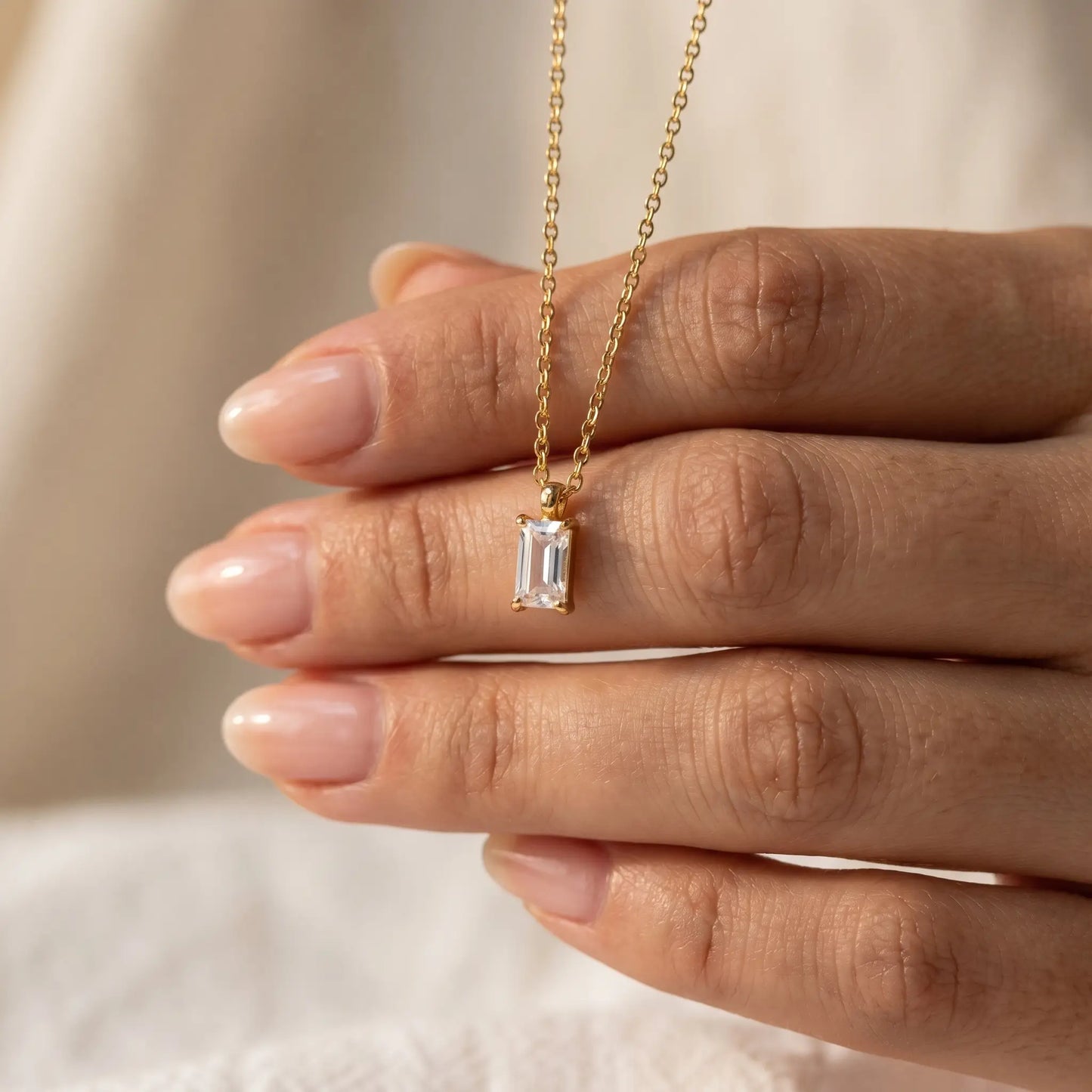 Baguette pendant necklace gold hand held