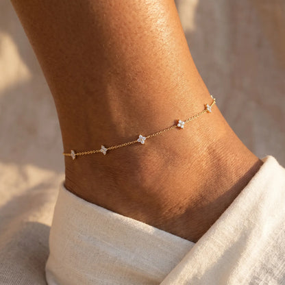 Gold four-leaf clover anklet worn on ankle close-up