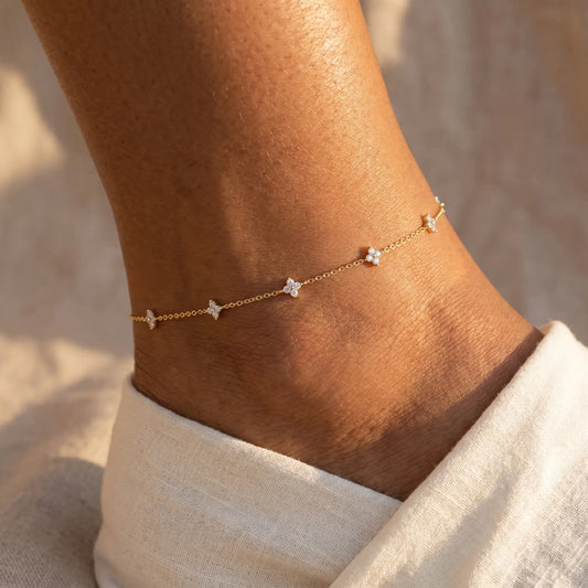 Gold four-leaf clover anklet worn on ankle close-up