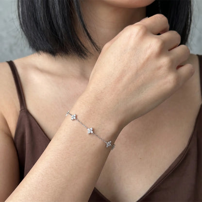 Clover charm dainty bracelet silver worn dorsal wrist close-up 4 quatrefoil CZ charms