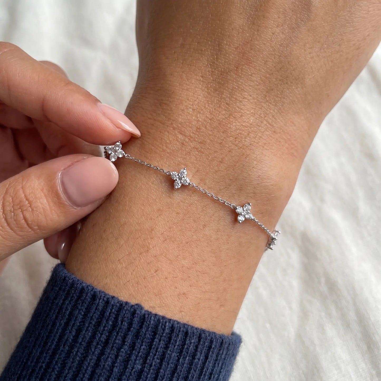 Silver clover bracelet intimate hand-to-jewelry tactile moment navy ribbed knit