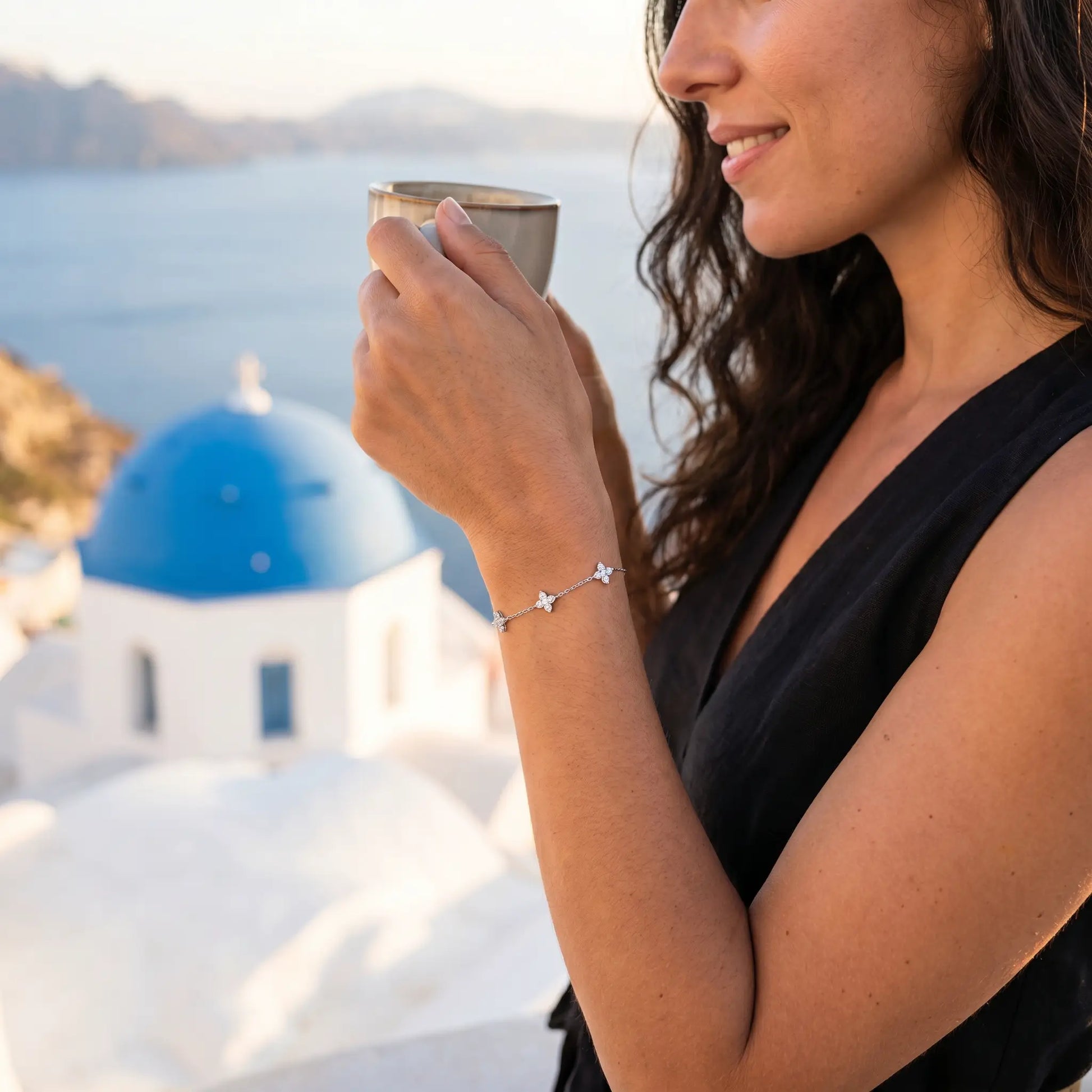 Silver clover bracelet profile subtle smile Santorini blue dome Spanish woman