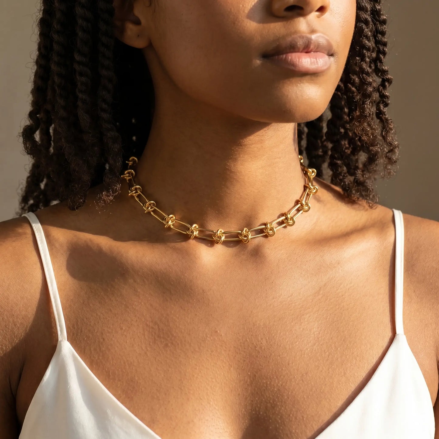 Knot chain necklace gold studio worn close-up on collarbone