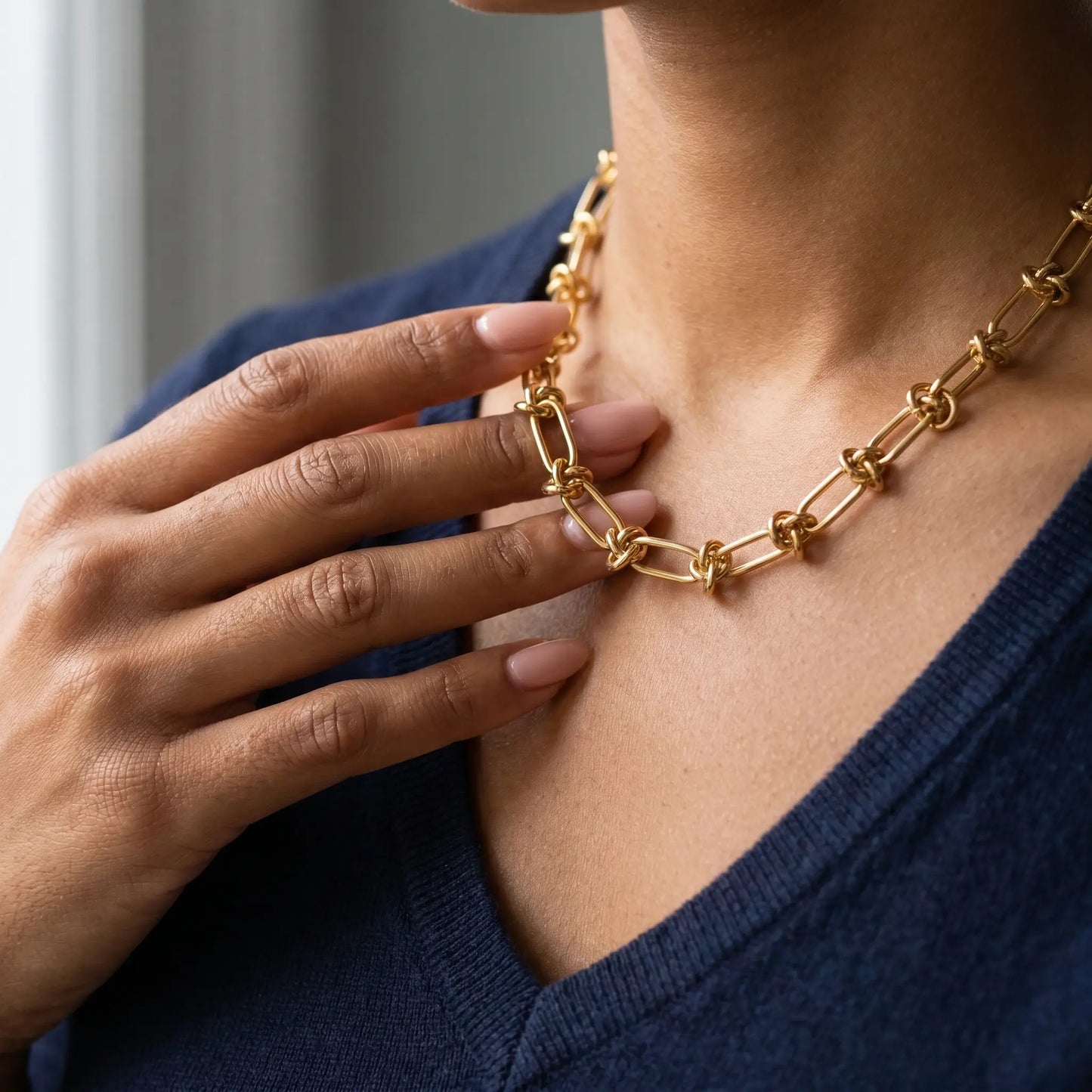 Knot chain necklace gold lifestyle hand to jewelry intimate close-up