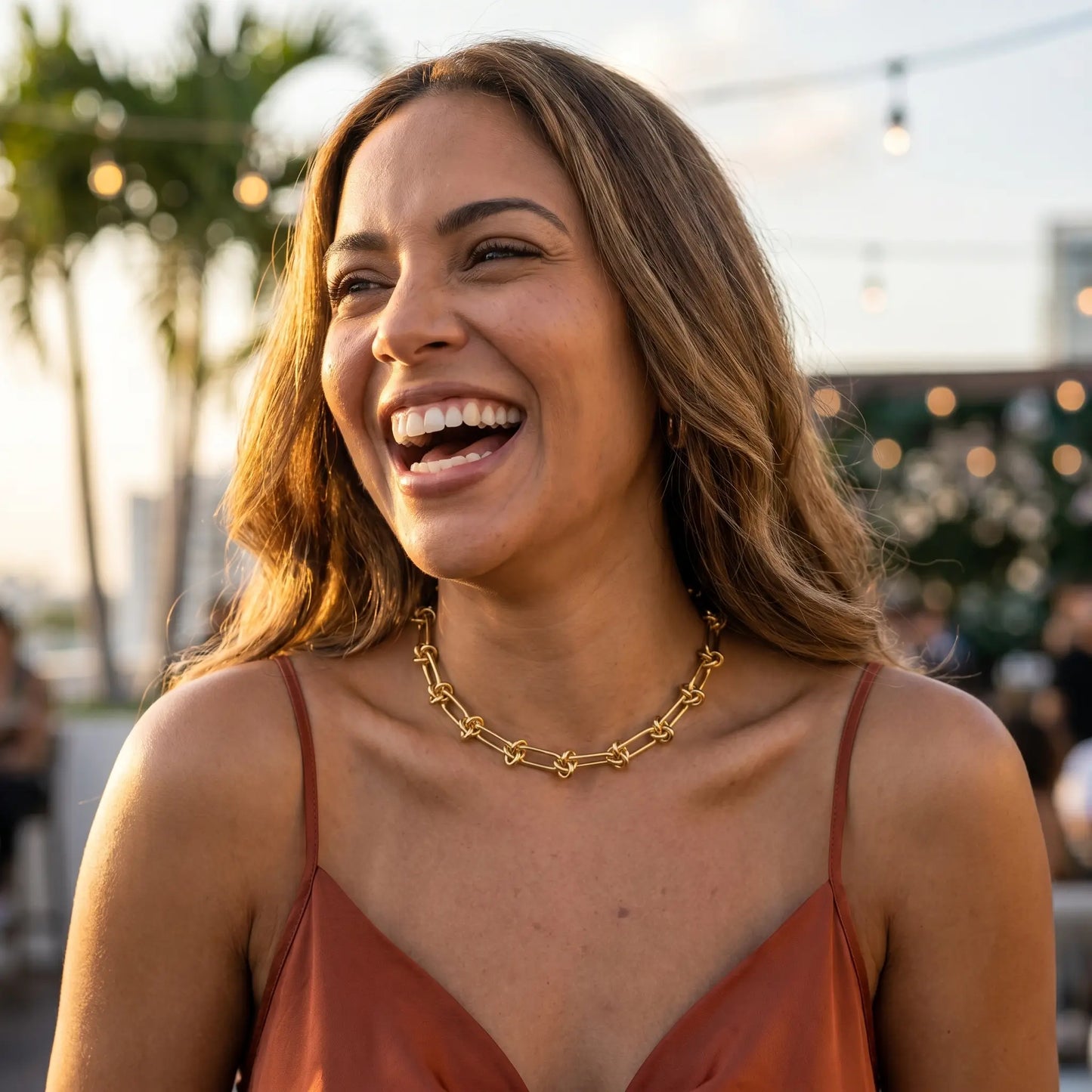 Knot chain necklace gold lifestyle joy half-laugh Miami rooftop golden hour