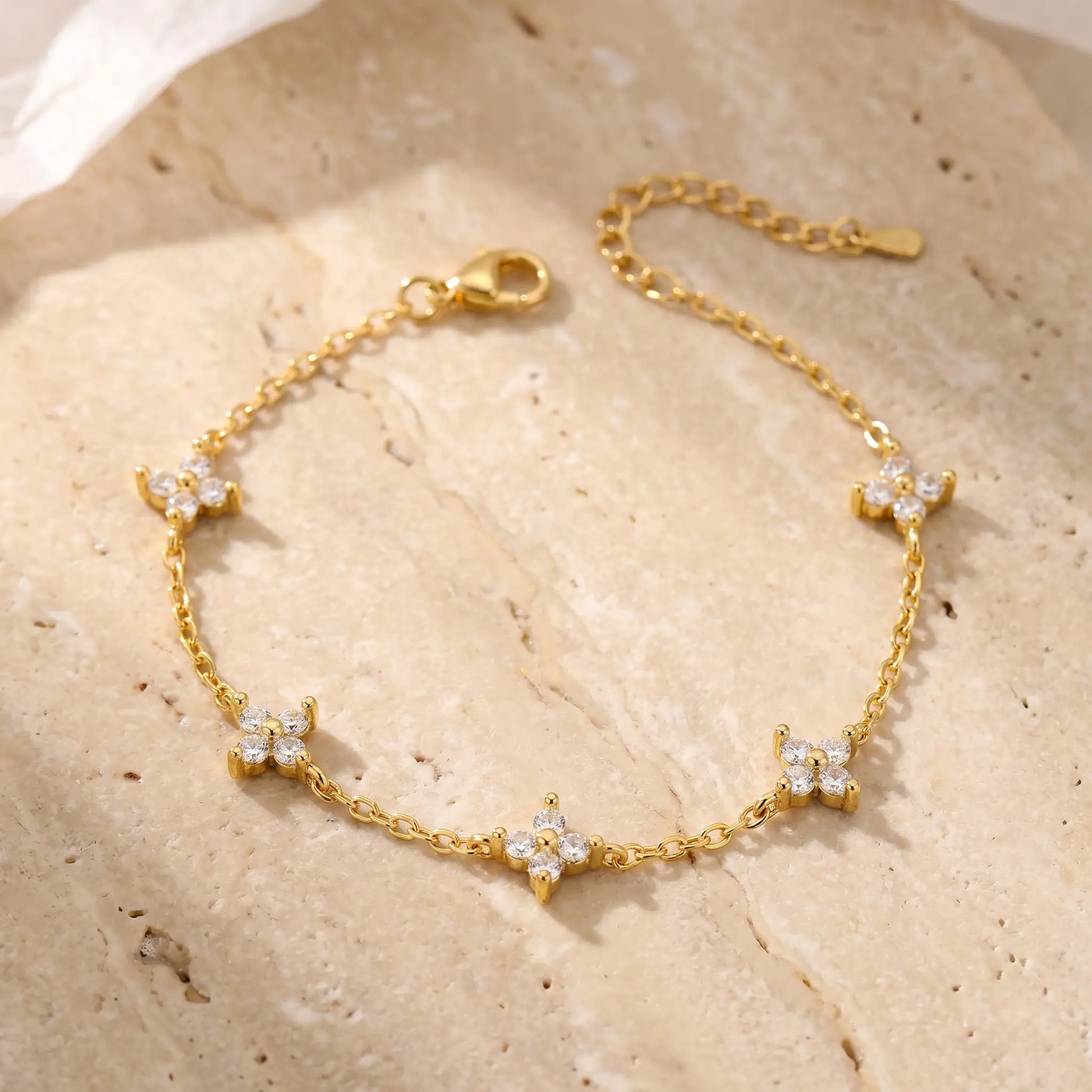FIX-5charms Gold clover bracelet packshot 5 quatrefoil CZ charms travertine