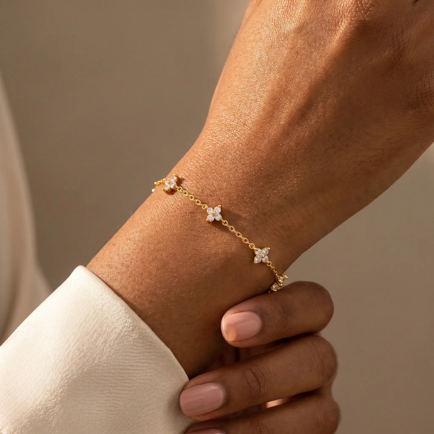 FIX-natural-pose Gold clover bracelet worn dorsal wrist 5 quatrefoil charms African American candid relaxed hand