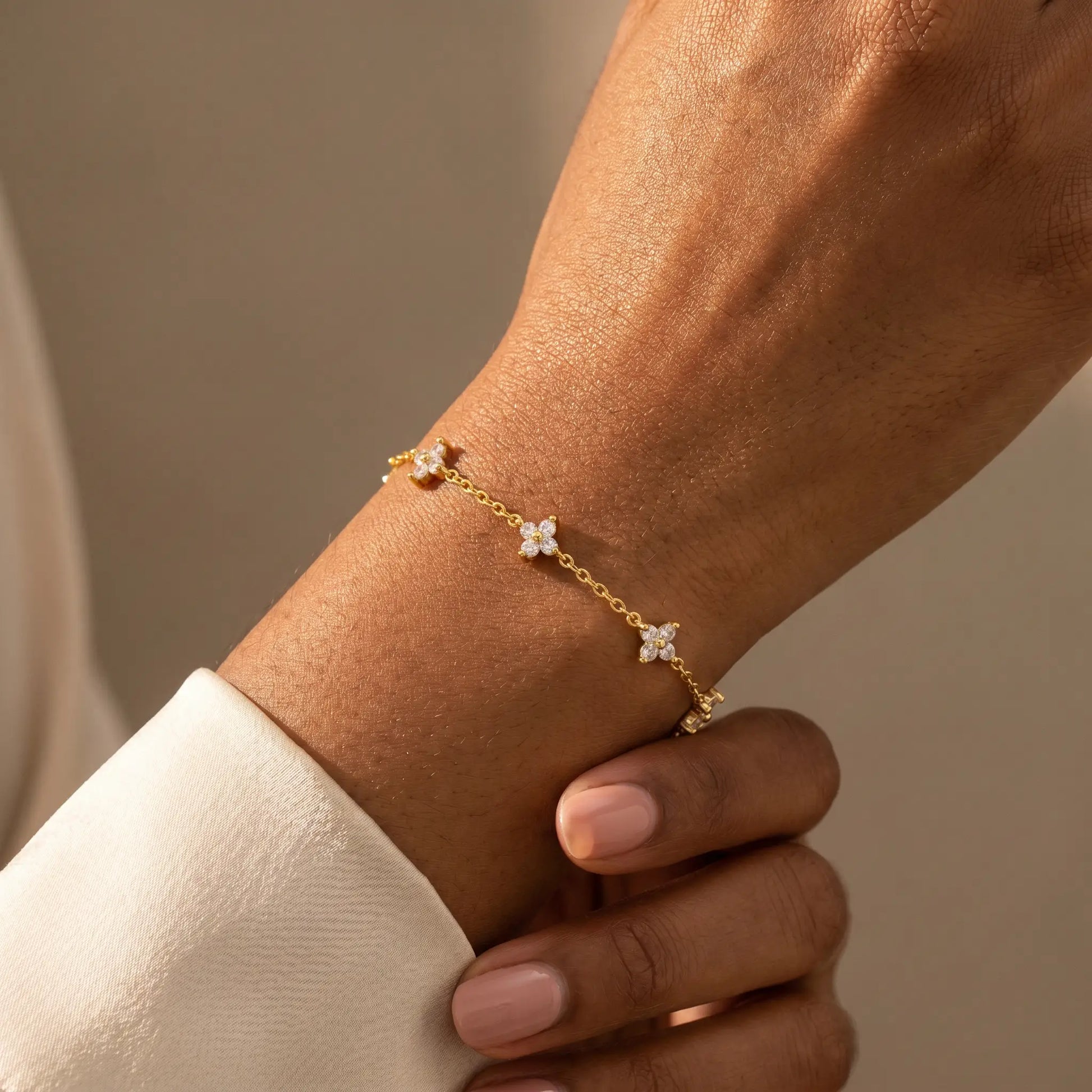 FIX-natural-pose Gold clover bracelet worn dorsal wrist 5 quatrefoil charms African American candid relaxed hand