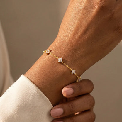 FIX-natural-pose Gold clover bracelet worn dorsal wrist 5 quatrefoil charms African American candid relaxed hand