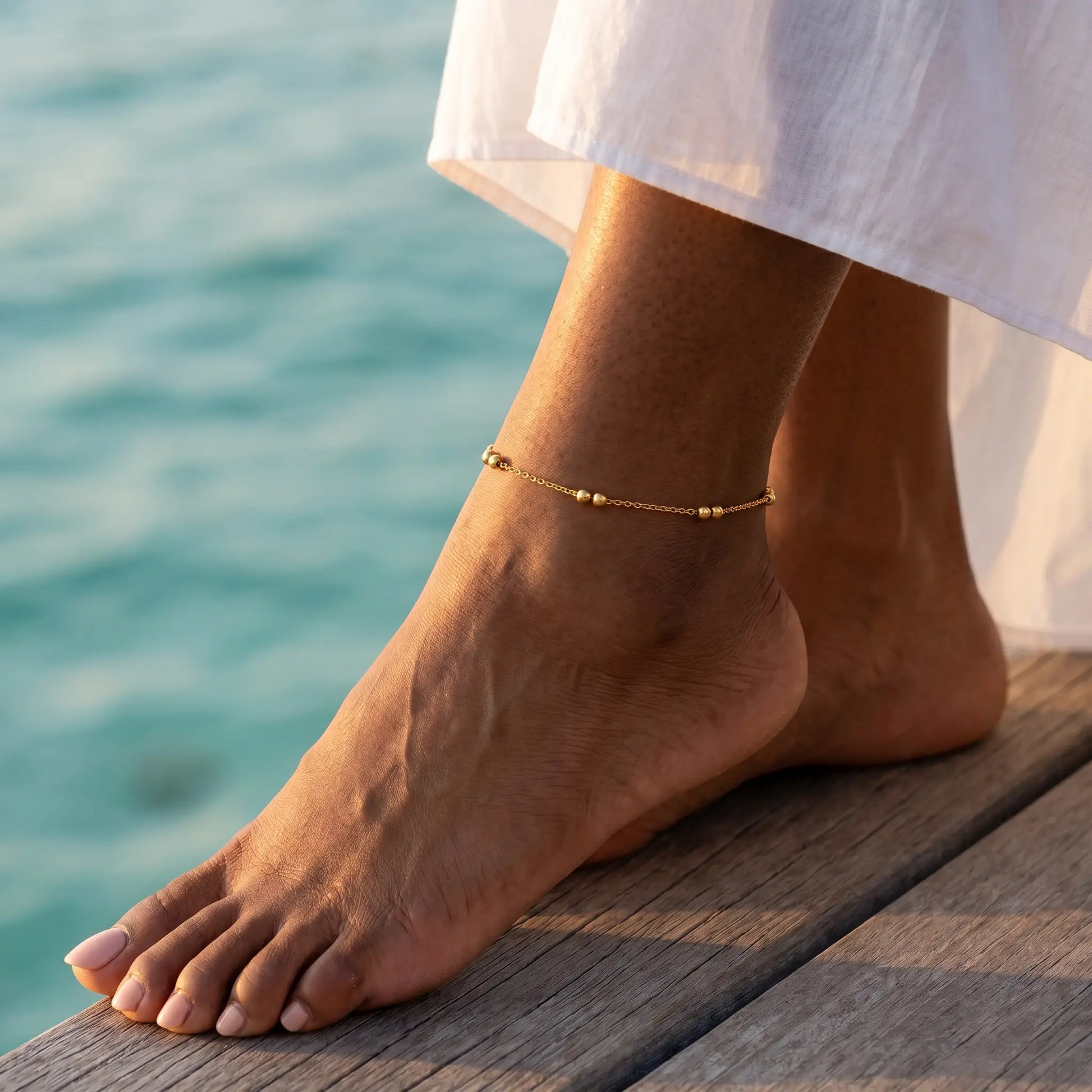 Beaded Station Anklet gold worn on Maldives overwater bungalow deck