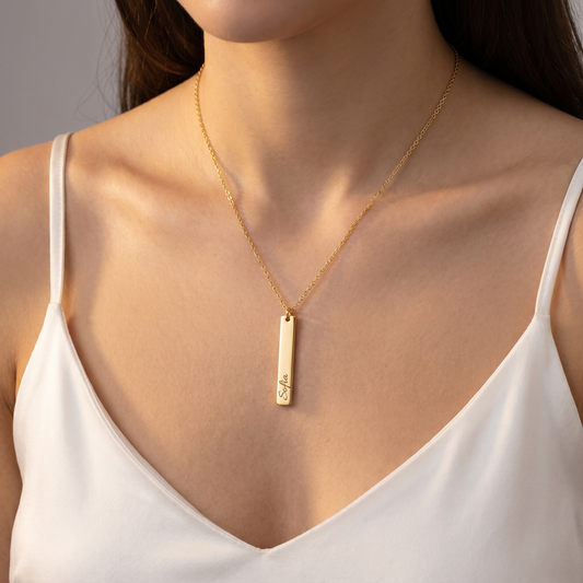 Gold vertical bar name necklace worn, hero