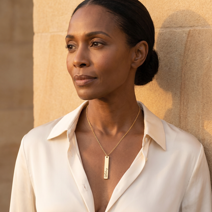 Gold vertical bar name necklace on mature woman