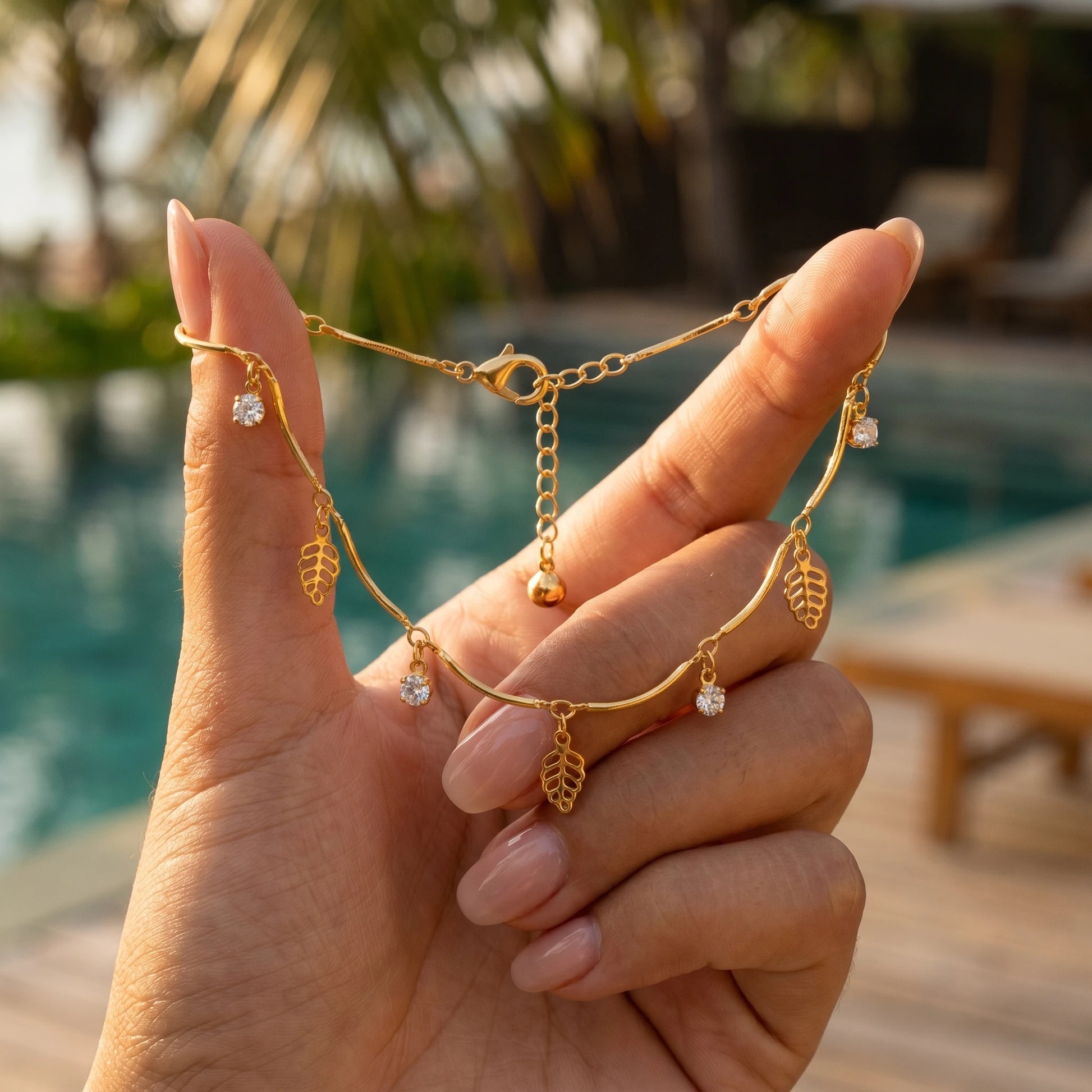 Gold leaf anklet hand-held tropical poolside golden hour