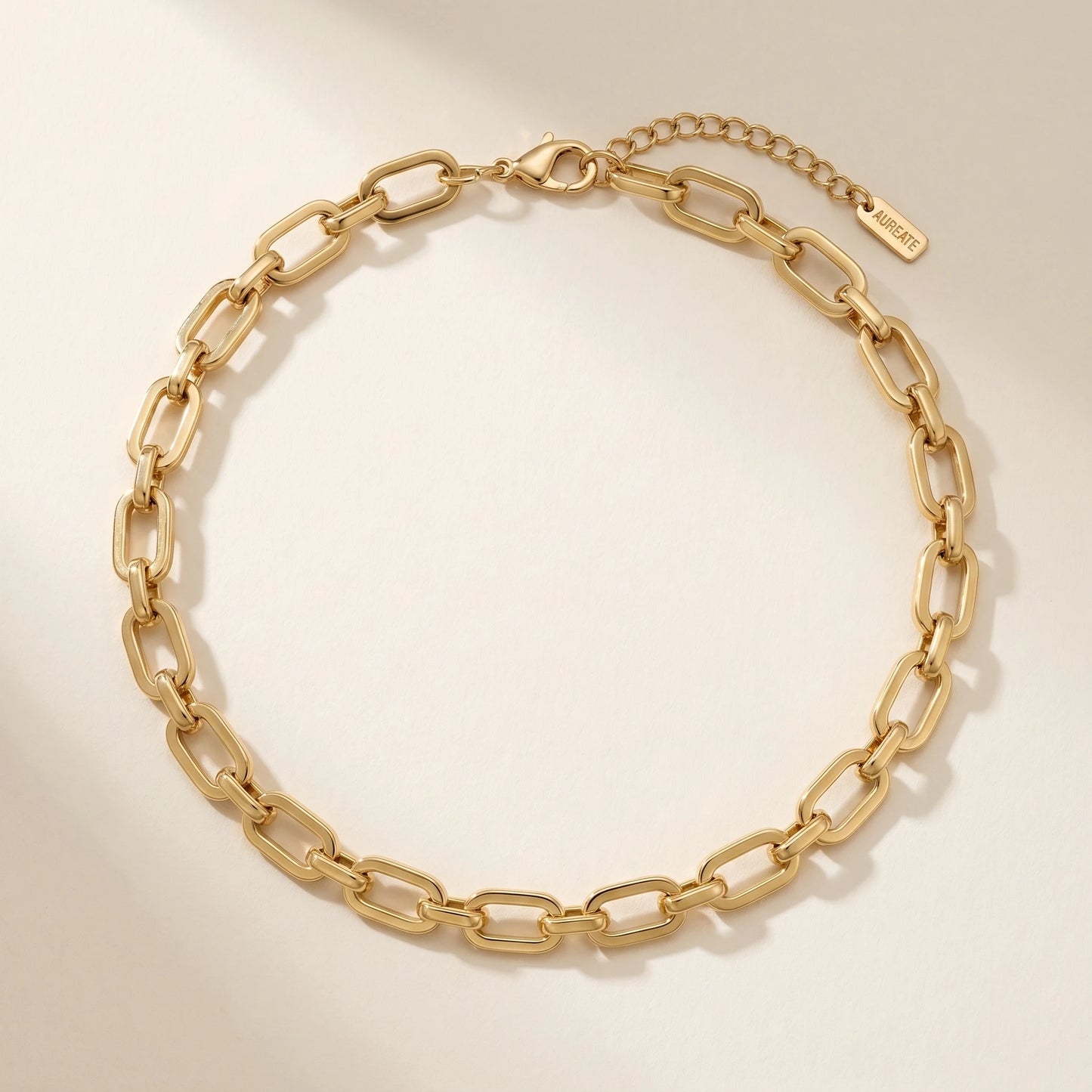 Chunky gold cable chain necklace packshot on cream paper