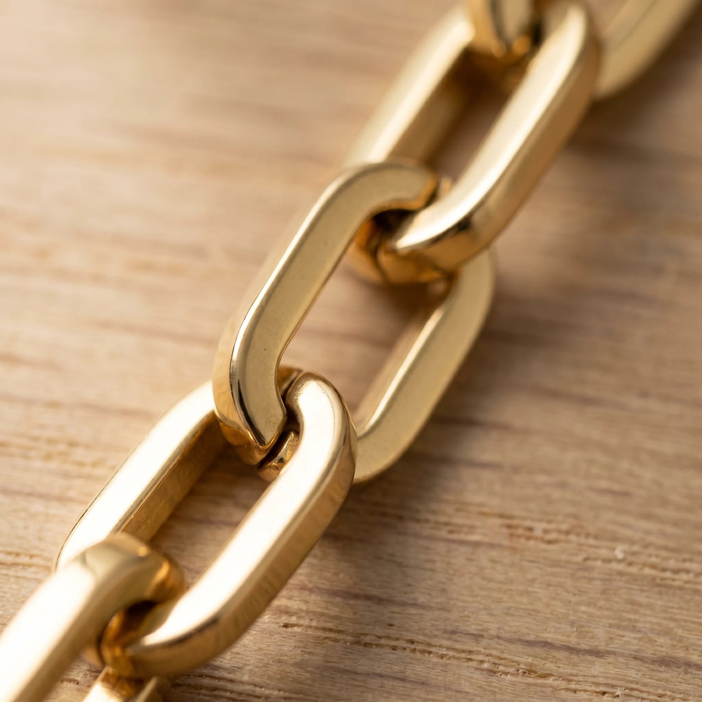 Chunky gold cable chain oval link macro detail perpendicular interlock