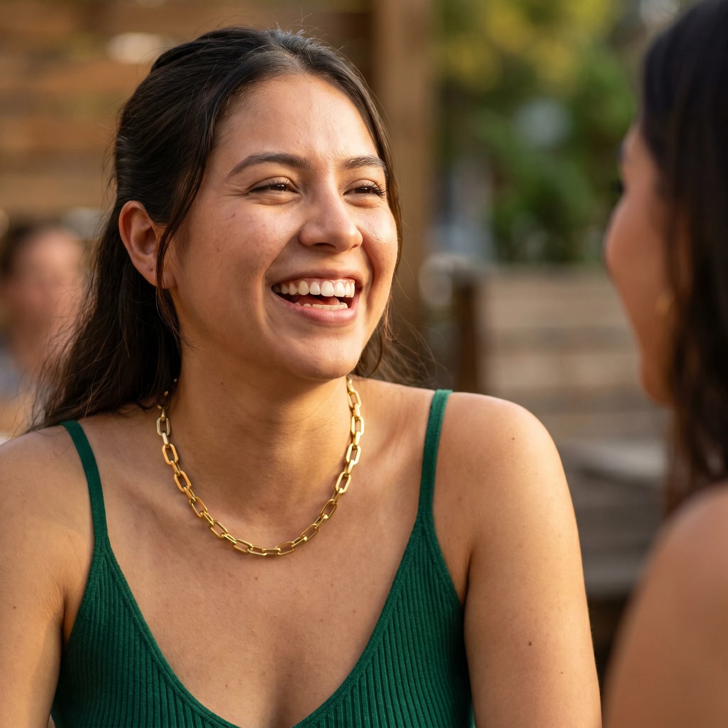 Woman laughing wearing chunky gold cable chain necklace golden hour