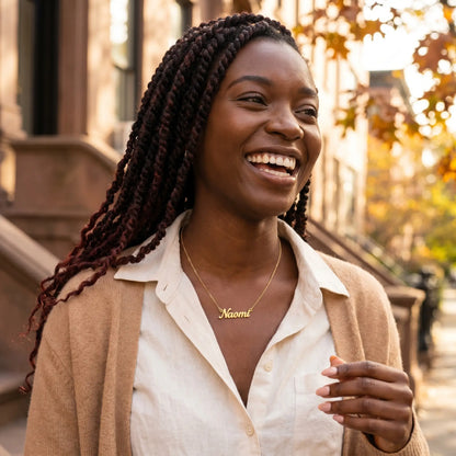 Personalised Plate Chain in 18K Gold by AUREATE worn by a woman named Naomi with a joyful smile.
