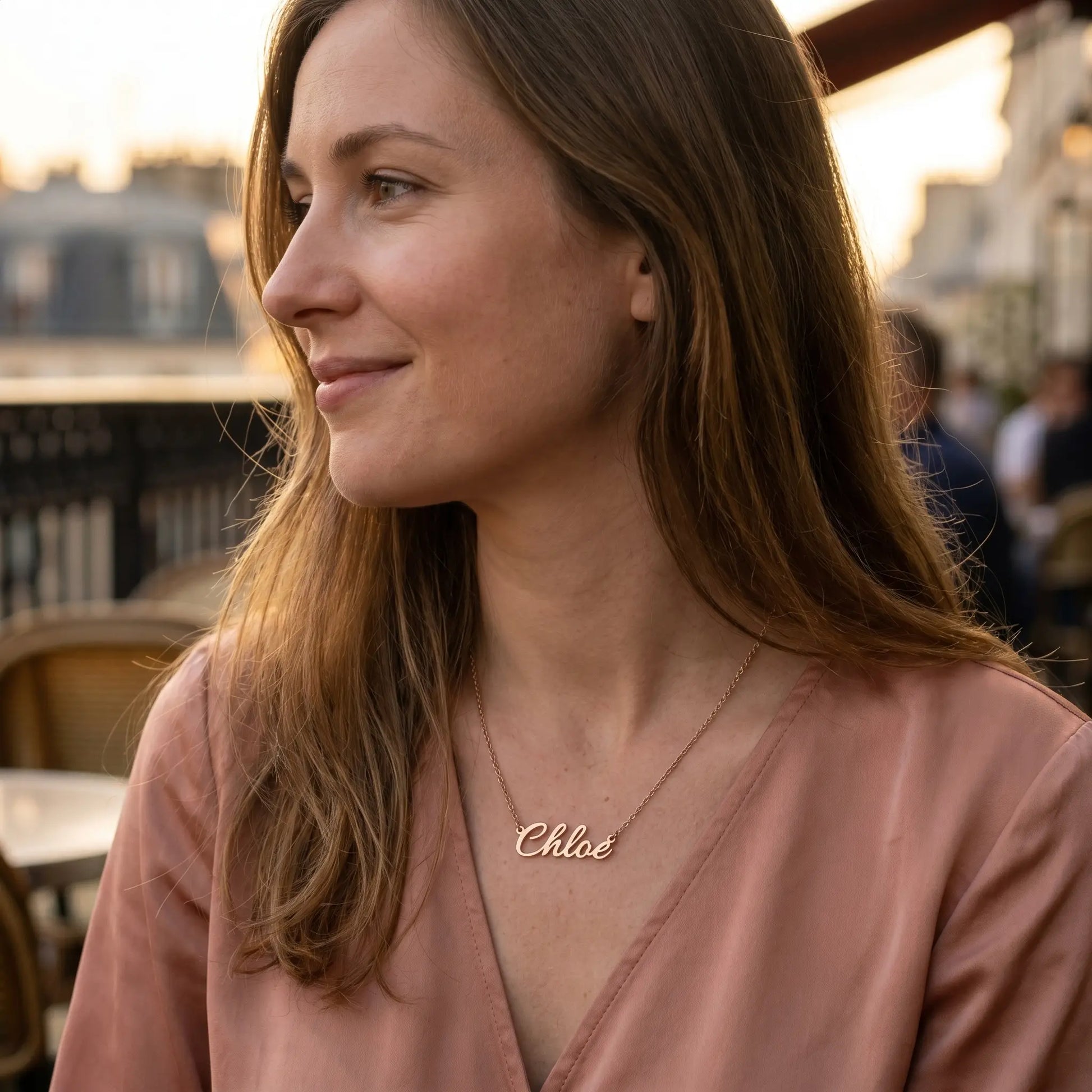Woman wearing a personalised plate chain in 18K gold by AUREATE, featuring the name 'Chloé'.