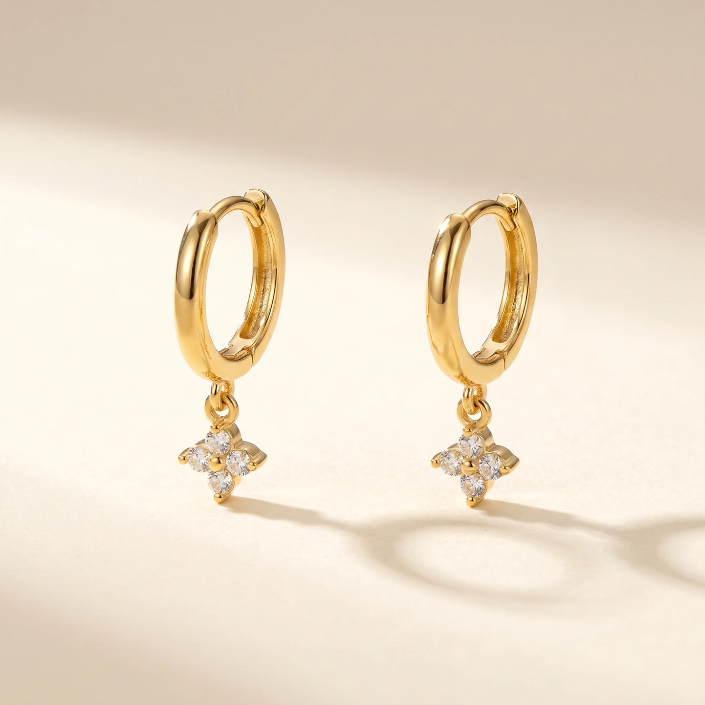 Gold petite clover huggie earrings packshot pair