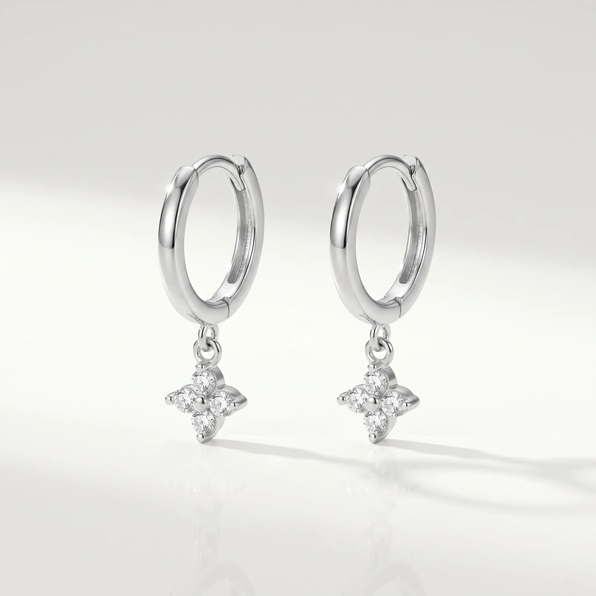 Silver petite clover huggie earrings packshot pair