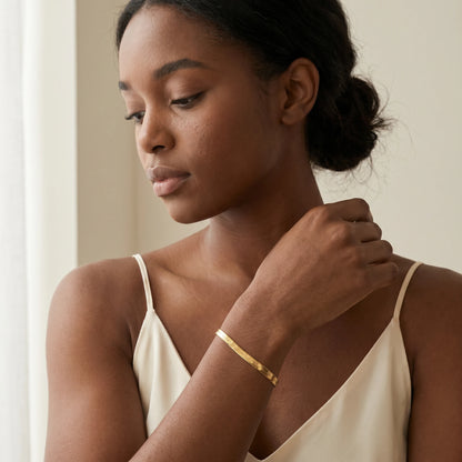 Gold herringbone bracelet on woman wrist worn close-up