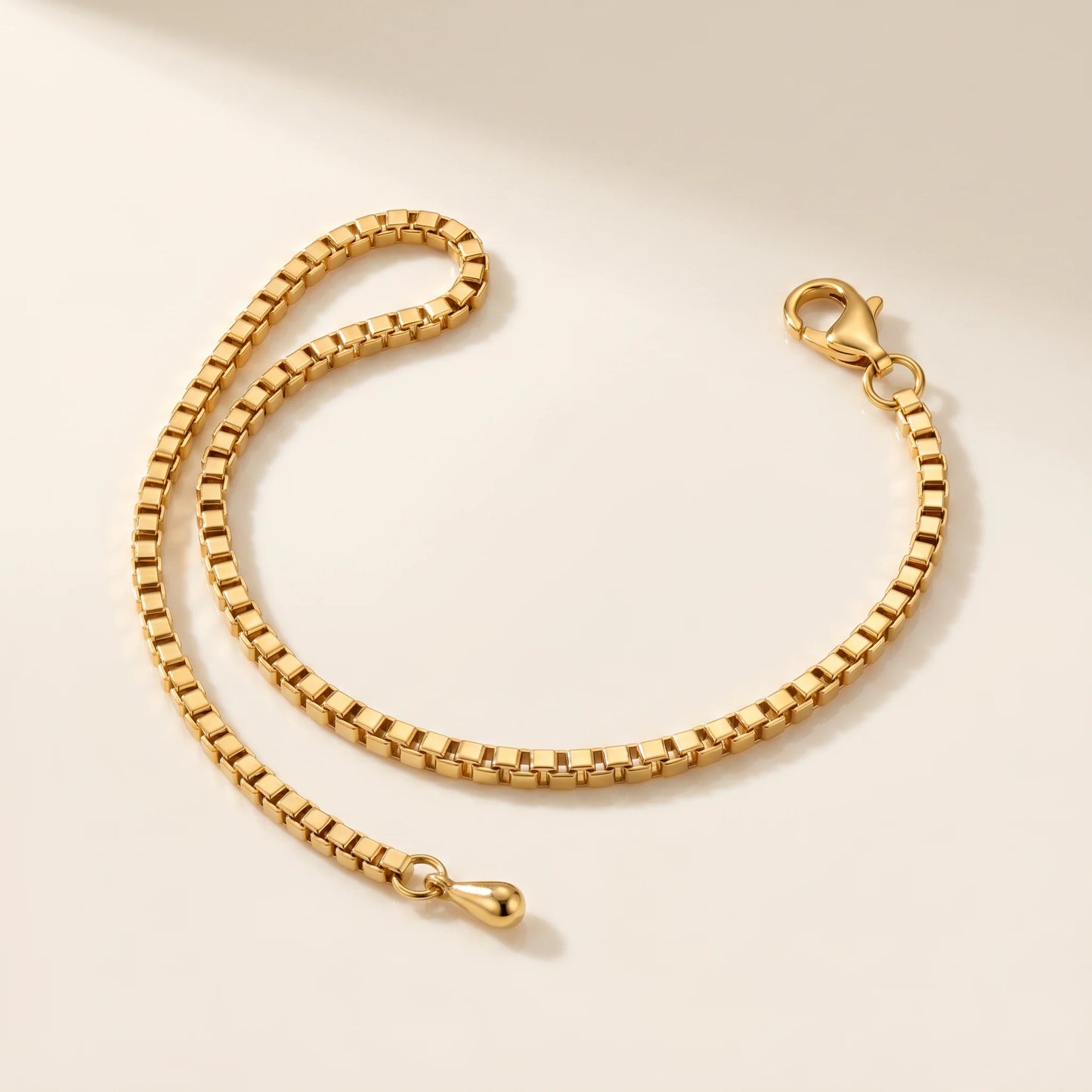 Box chain anklet gold packshot off-white background Venetian square link