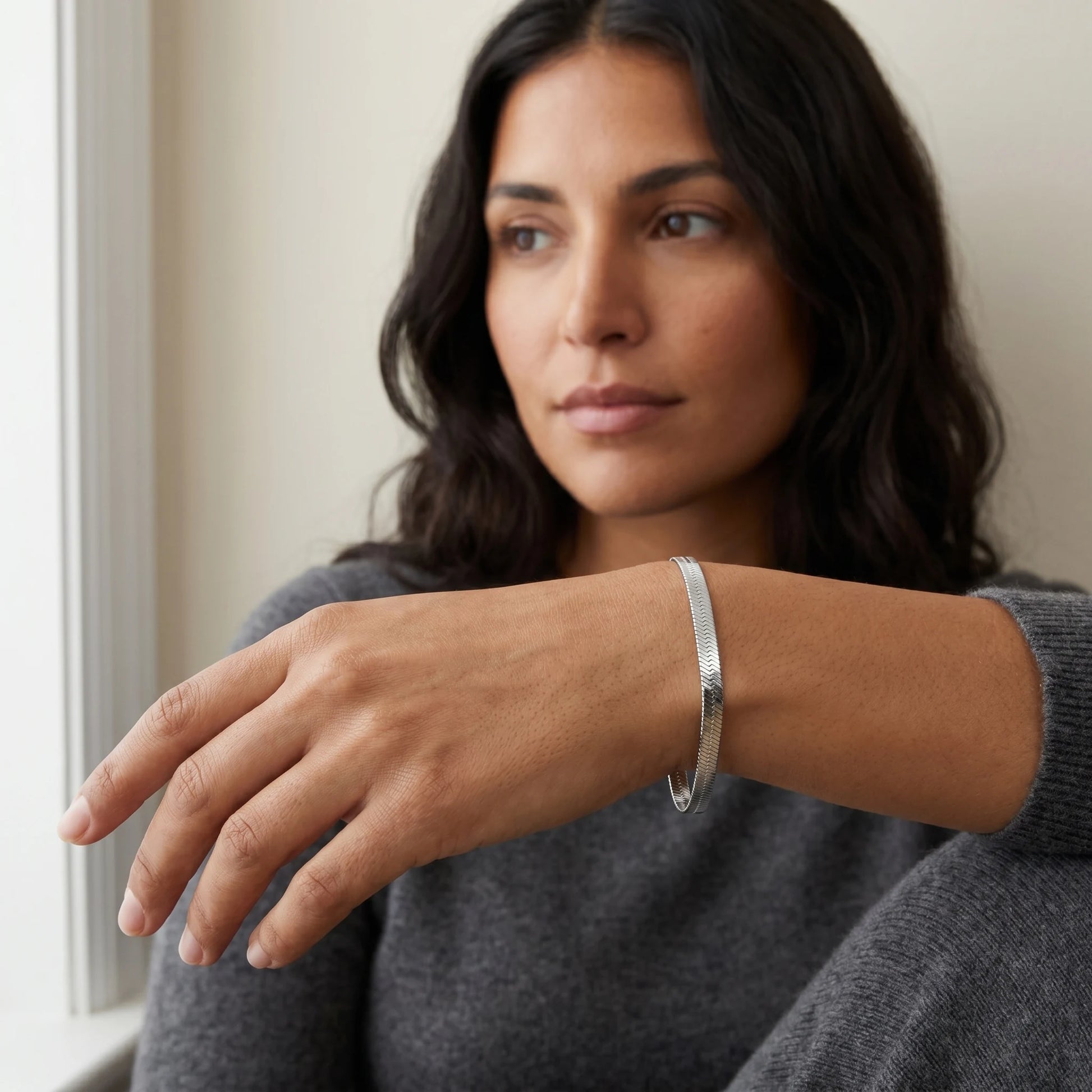 Silver herringbone bracelet worn close-up