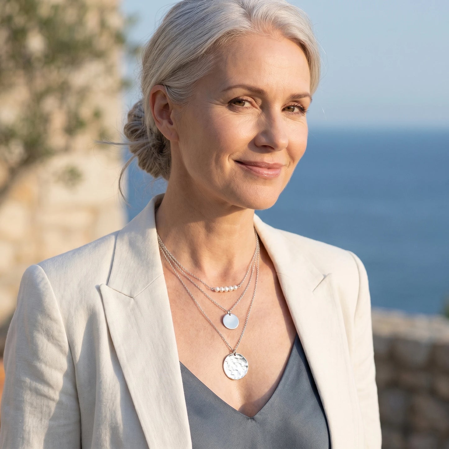 Mature blonde woman wearing silver pearl coin layered necklace set