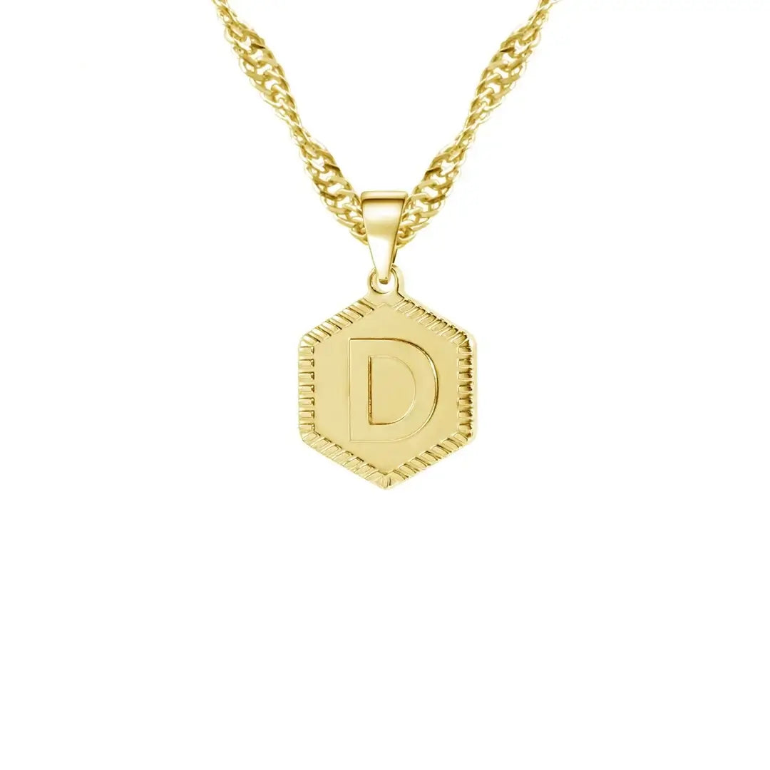 Hexagon Initial Necklace by AUREATE featuring a gold pendant with initial 'D' on a wave chain.