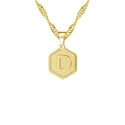 Hexagon Initial Necklace by AUREATE featuring a gold pendant with initial 'D' on a wave chain.