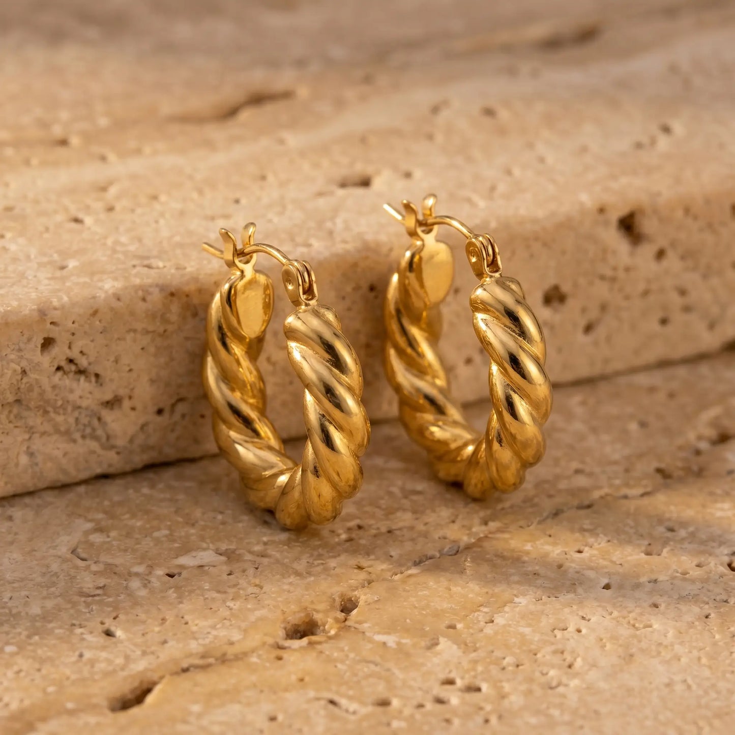Twisted Gold Hoop Earrings pair - packshot on travertine