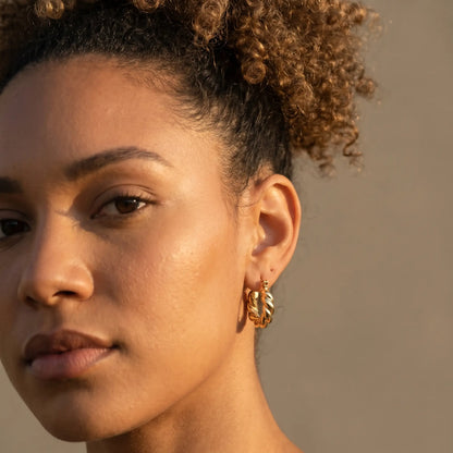 Woman wearing Twisted Gold Hoop Earrings - studio close-up editorial