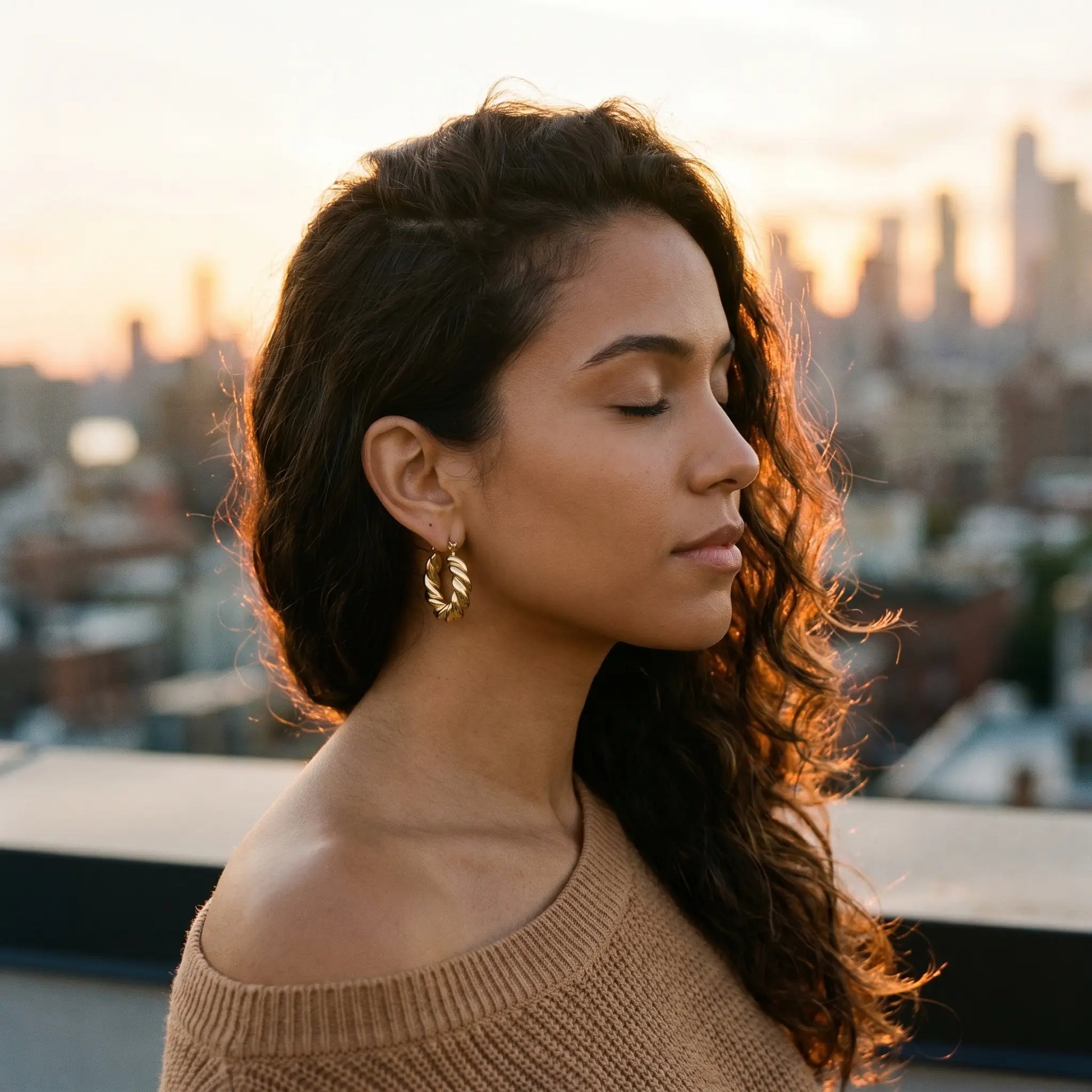 Woman on rooftop wearing Twisted Gold Hoop Earrings - sunset lifestyle