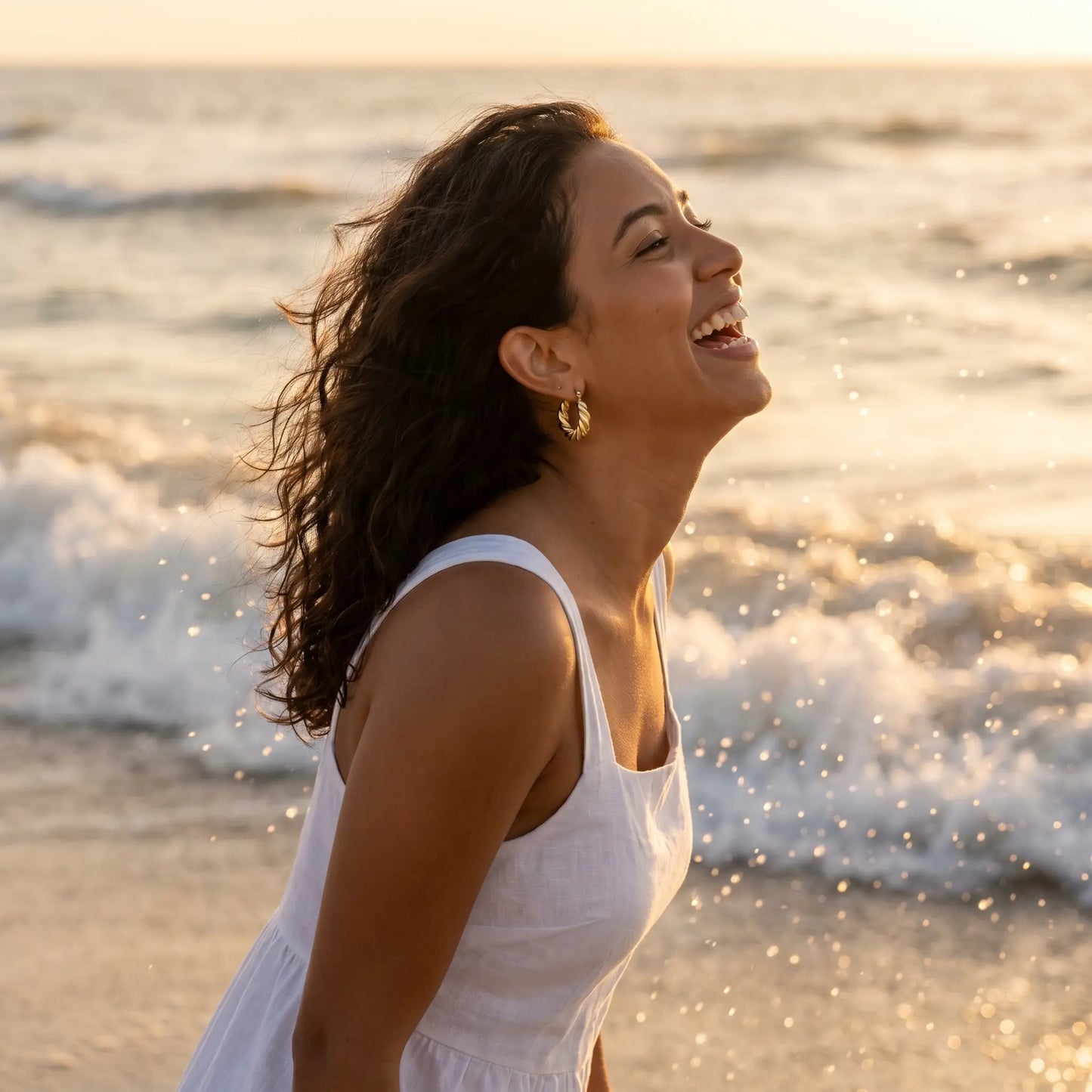 Woman on beach wearing Twisted Gold Hoop Earrings - waterproof sunset