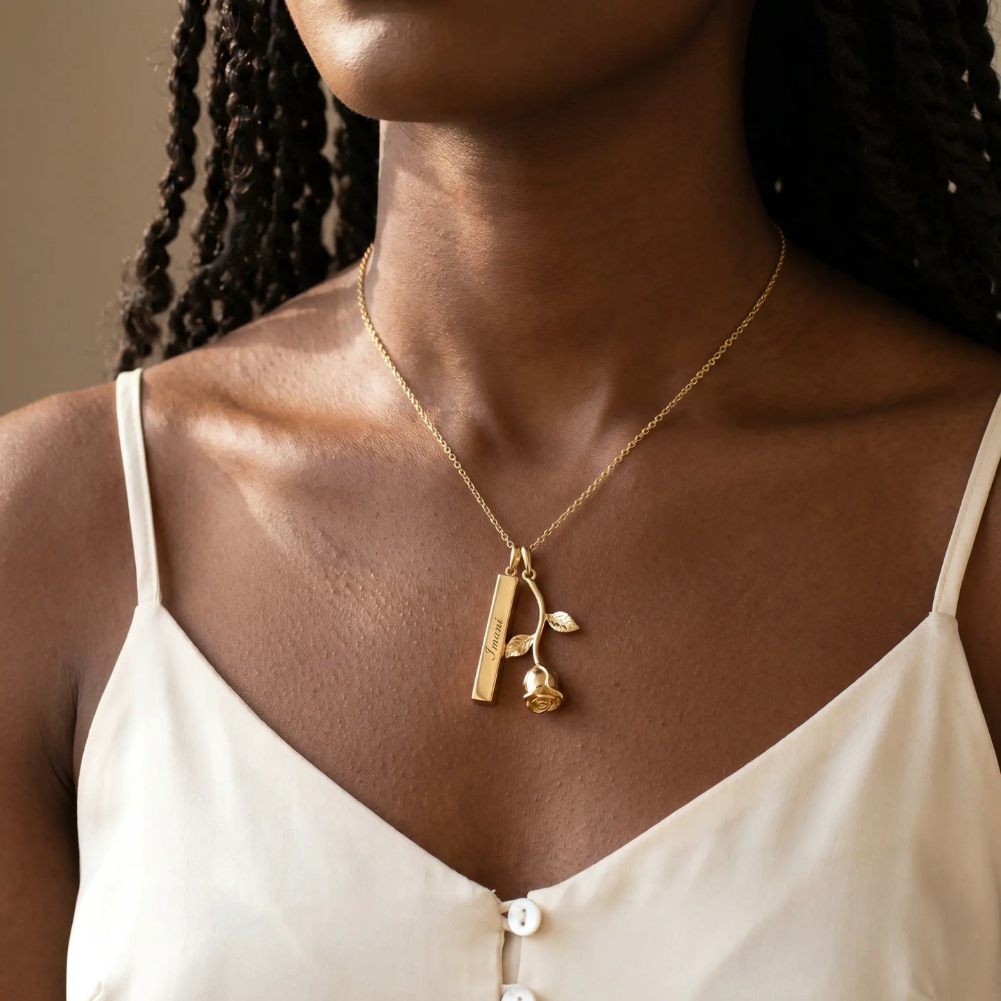 Rose Gold Engraved Bar Pendant in 18K gold worn by woman with engraved name Imani at collarbone