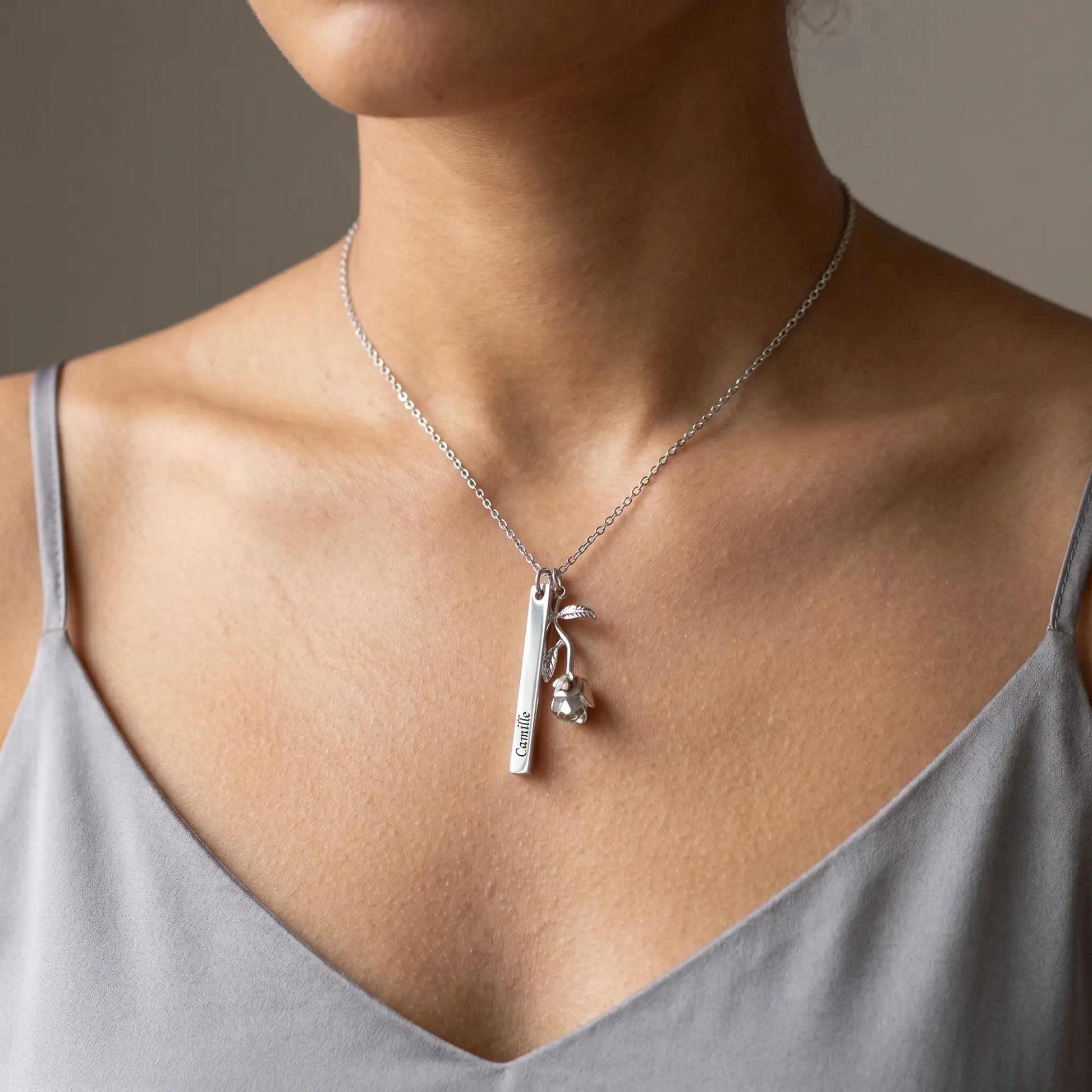 Rose Gold Engraved Bar Pendant in silver tone worn by woman with engraved name Camille at collarbone