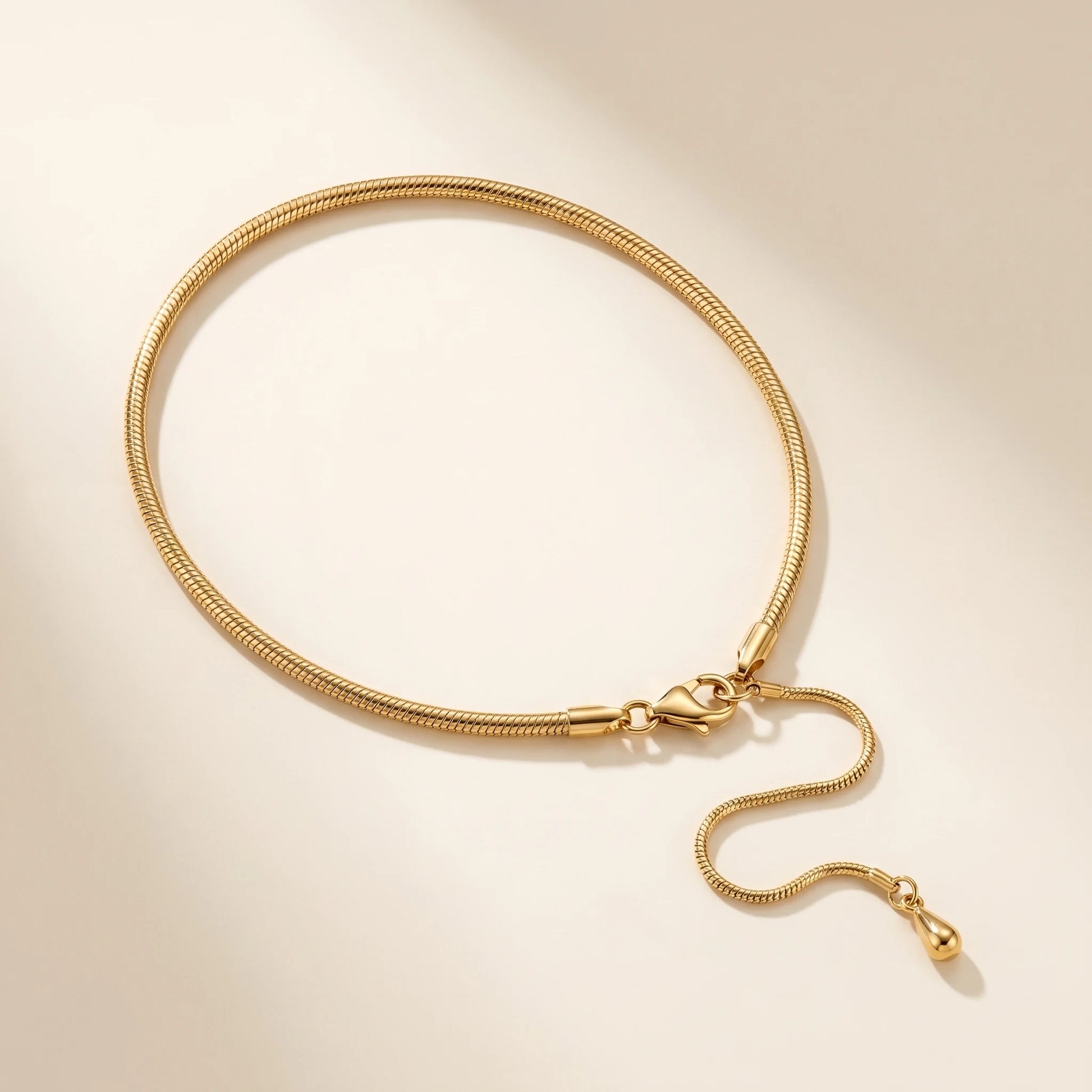 Gold snake chain anklet studio packshot off-white with lobster clasp and teardrop extension