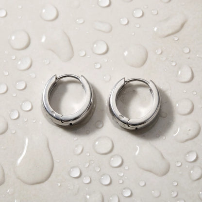 Silver tone stainless steel chunky dome hoop earrings, still life on a wet surface, waterproof | SKU: AUR-CHKDOM-S