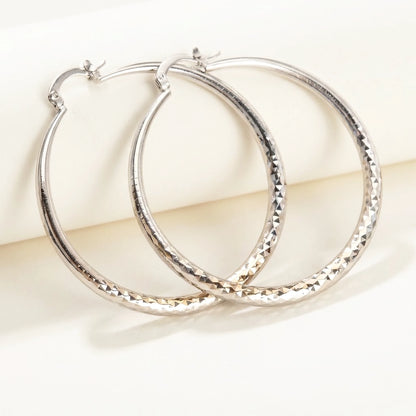 Silver tone stainless steel diamond cut large hoop earrings, product shot on white | SKU: AUR-DCTHOP-S