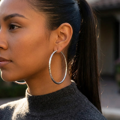 Silver tone stainless steel diamond cut large hoop earrings, worn, side profile | SKU: AUR-DCTHOP-S