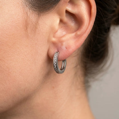 Silver tone stainless steel pave huggie hoop earrings, macro detail on the earlobe | SKU: AUR-PVHUGG-S