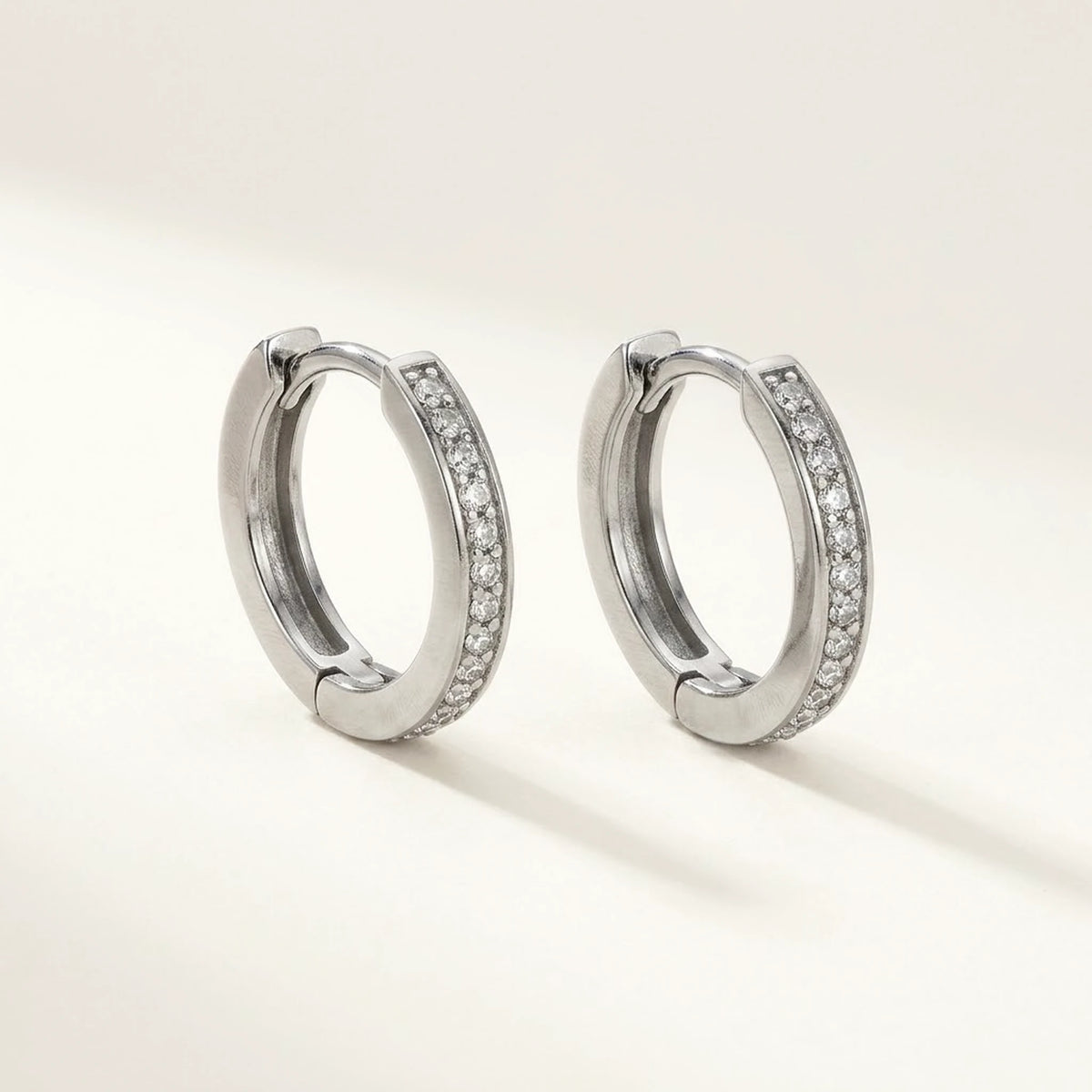 Silver tone stainless steel pave huggie hoop earrings, product shot on white | SKU: AUR-PVHUGG-S