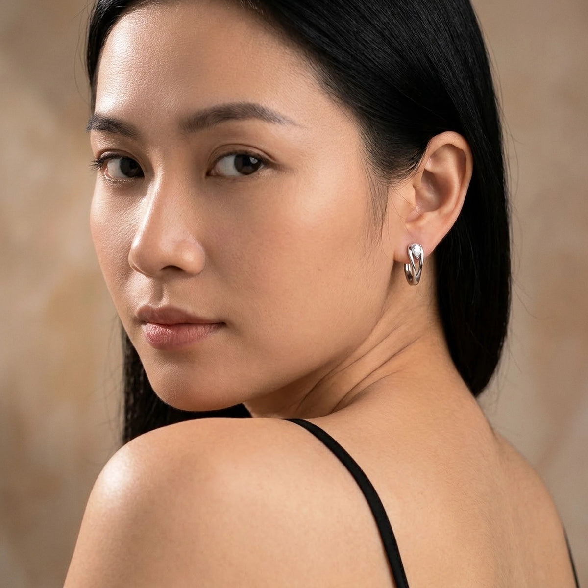 Silver tone stainless steel pear cut crystal huggie hoop earrings, worn, over the shoulder portrait | SKU: AUR-PRCZHG-S