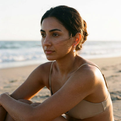 Silver tone stainless steel freshwater pearl drop huggie earrings, worn on the beach | SKU: AUR-PRLHUG-S