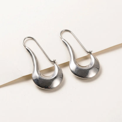 Silver tone stainless steel sculpted crescent drop earrings, product shot on white | SKU: AUR-SCPCRS-S