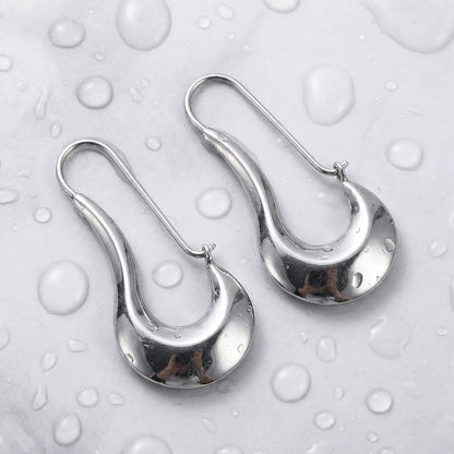Silver tone stainless steel sculpted crescent drop earrings, still life on a wet surface, waterproof | SKU: AUR-SCPCRS-S