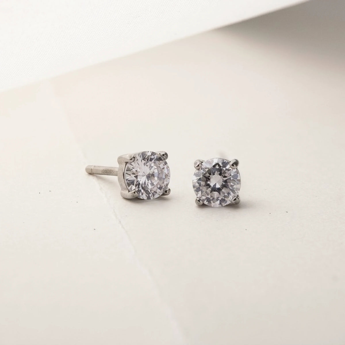 Silver tone stainless steel cubic zirconia solitaire stud earrings, product shot on white | SKU: AUR-SOLSTD-S