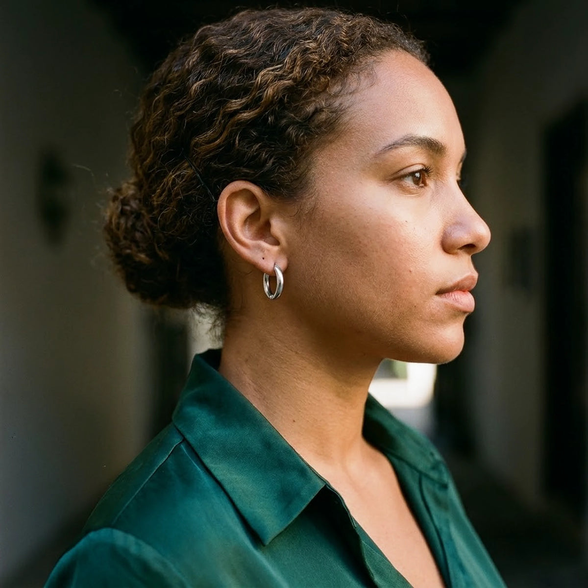 Silver tone stainless steel tiny huggie hoop earrings, worn, side profile | SKU: AUR-TNYHUG-S