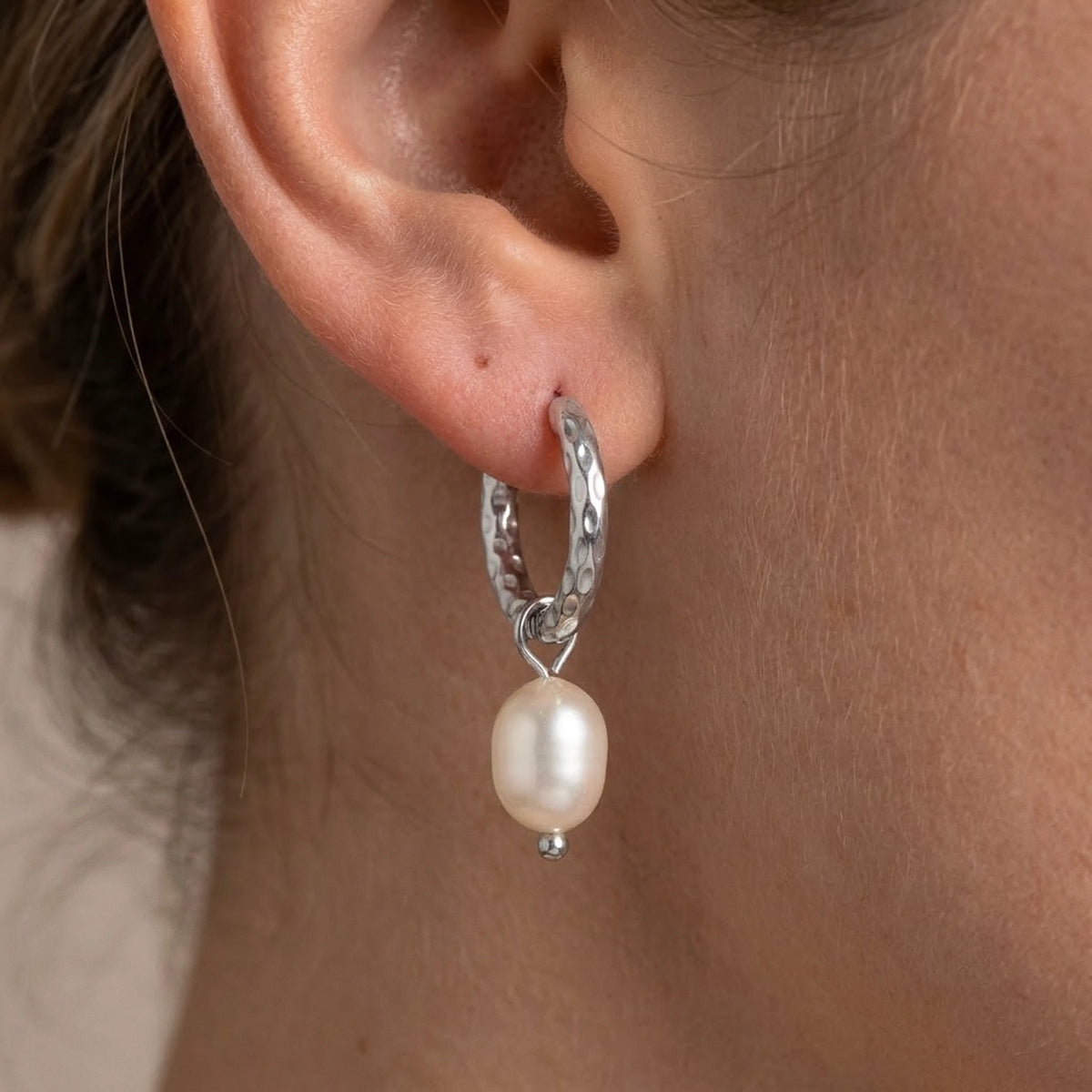 Silver tone stainless steel twisted rope pearl drop hoop earrings, macro detail on the earlobe | SKU: AUR-TWPRLH-S
