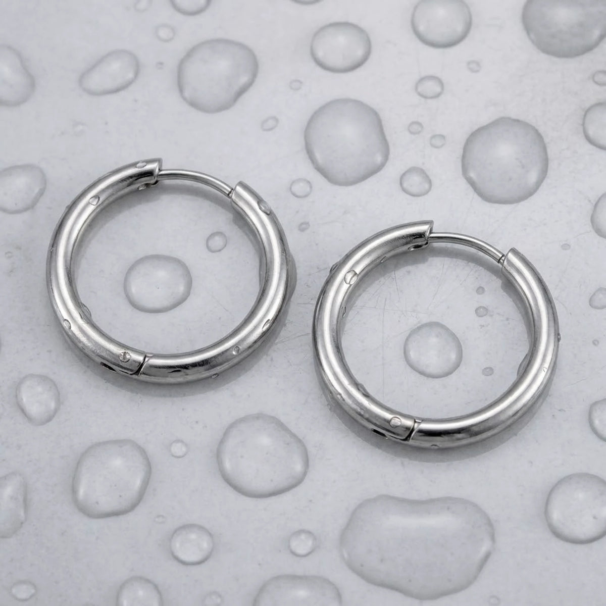 Silver tone stainless steel waterproof hoop earrings, still life on a wet surface, waterproof | SKU: AUR-CLSHOP-S